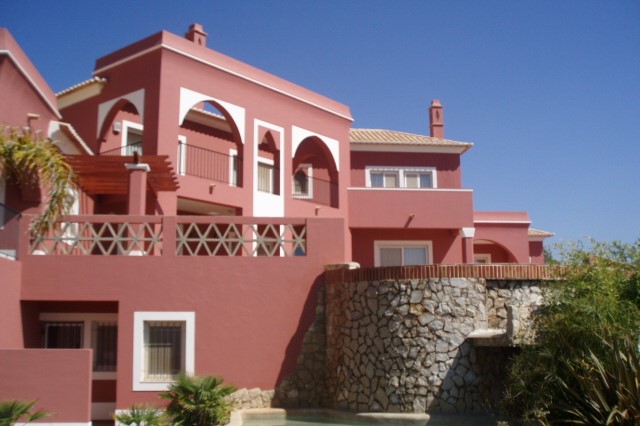 Terraço superior com arcos e fachada vermelha na Quinta do Monte Funchal