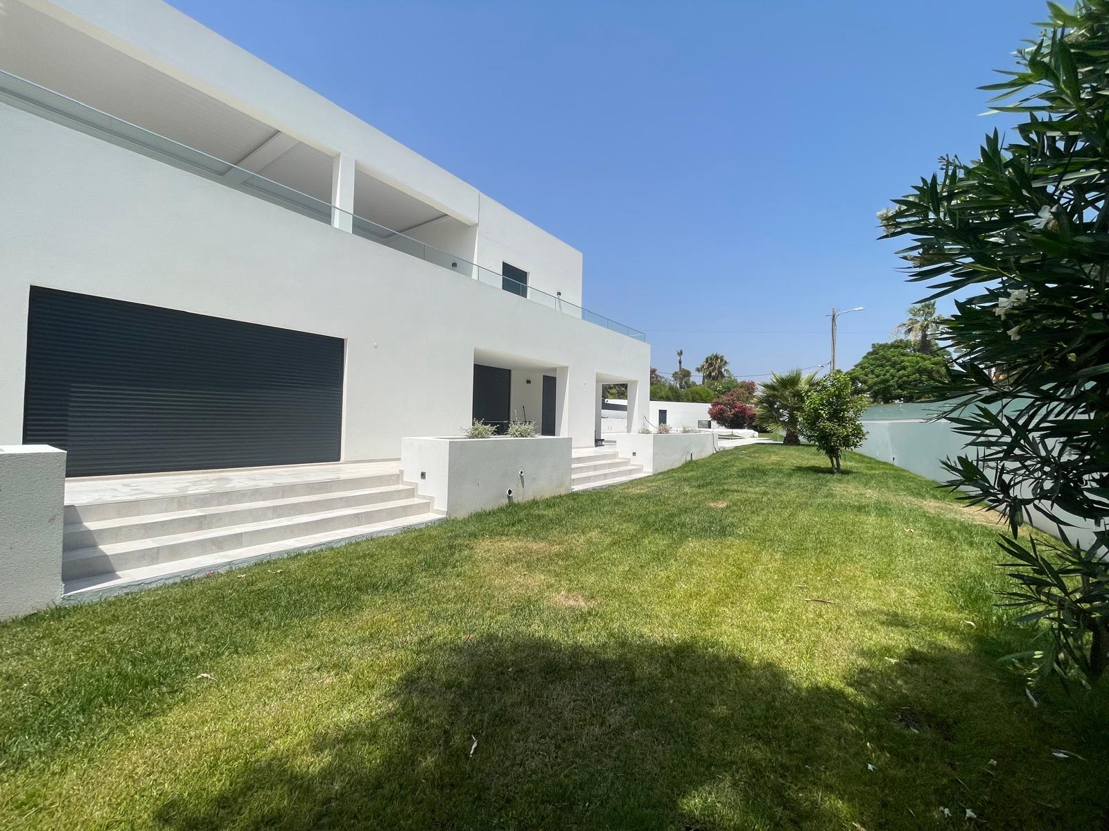 Fachada lateral e jardim da moradia renovada em Vale Centeanes